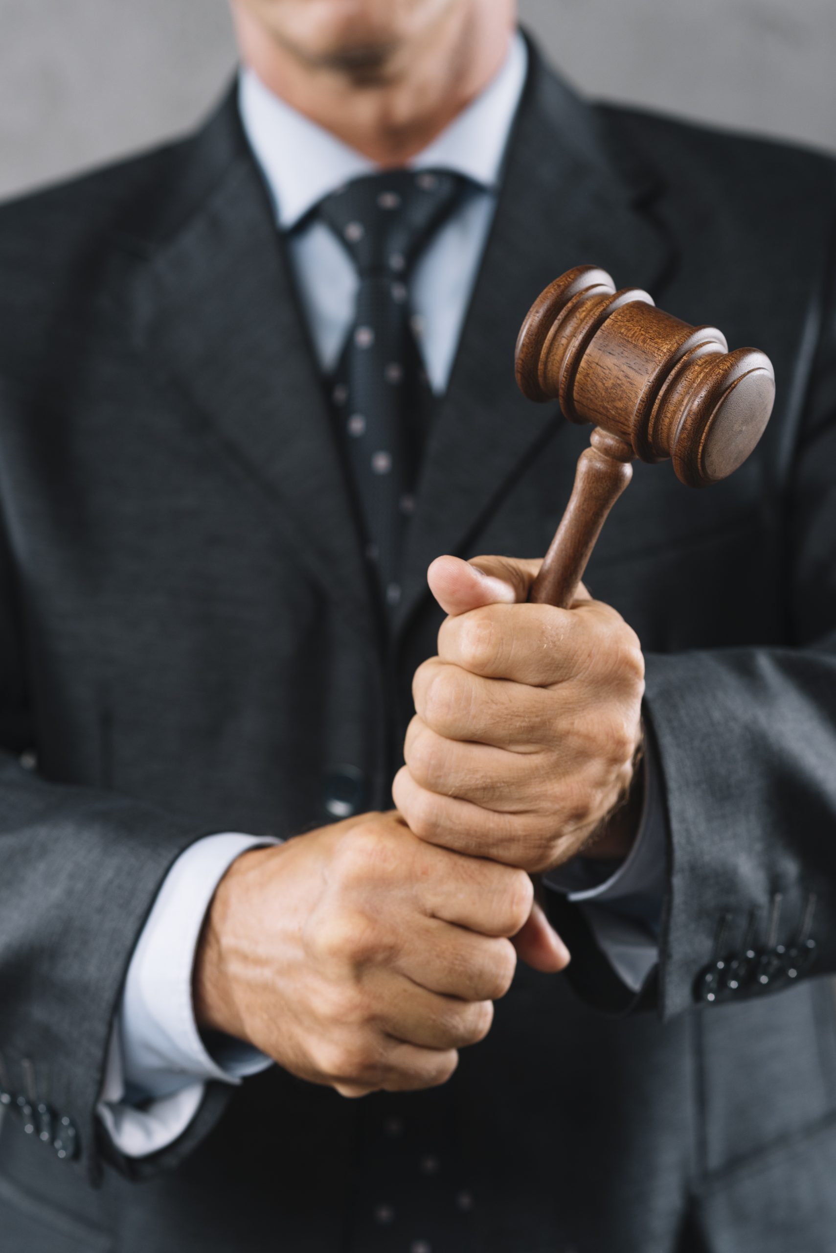 mid section male lawyer holding wooden mallet hand scaled